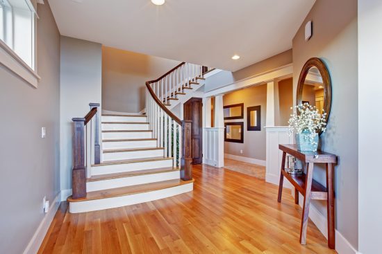 beige and white foyer entrance with a staircase