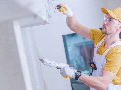 painter performing drywall repair