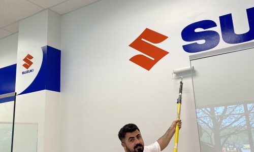 Employee Painting Wall with Company Logo