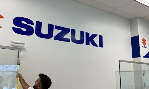 Employee Painting Wall with Company Logo