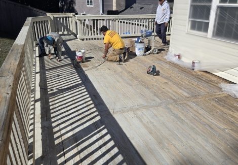 painters staining an old deck