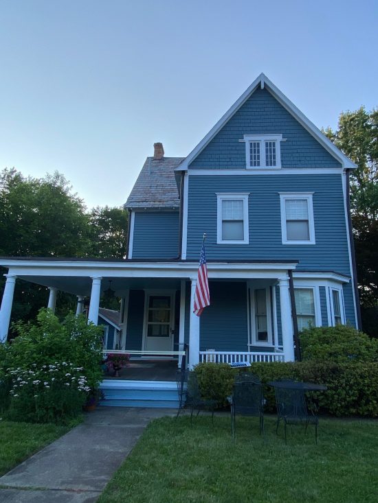 front of house with blue siding and whit trim