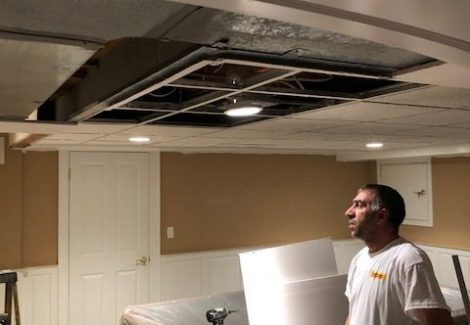 painter inspecting damaged ceiling