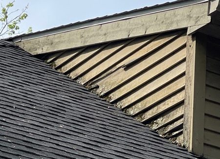 damaged wood trim and siding on upper level of house
