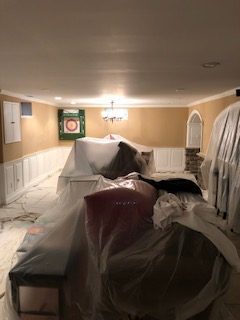 preparations being made before repairs and painting, plastic covered furniture