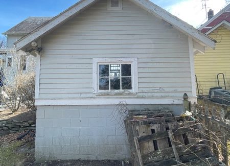side of house with worn white siding