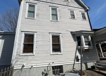 side of house with worn white siding