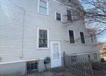 side of house with worn white siding