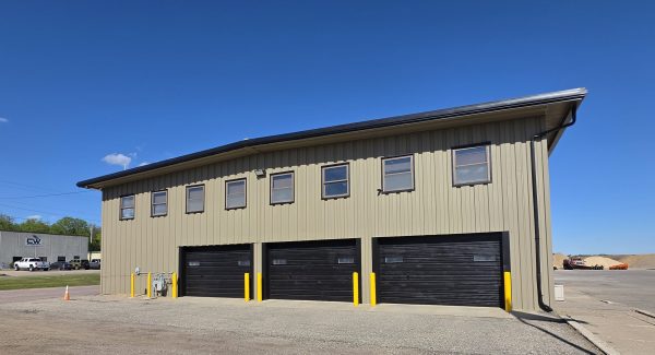 grey khaki commercial warehouse building with large black garage doors in Le Center, Minnesota.