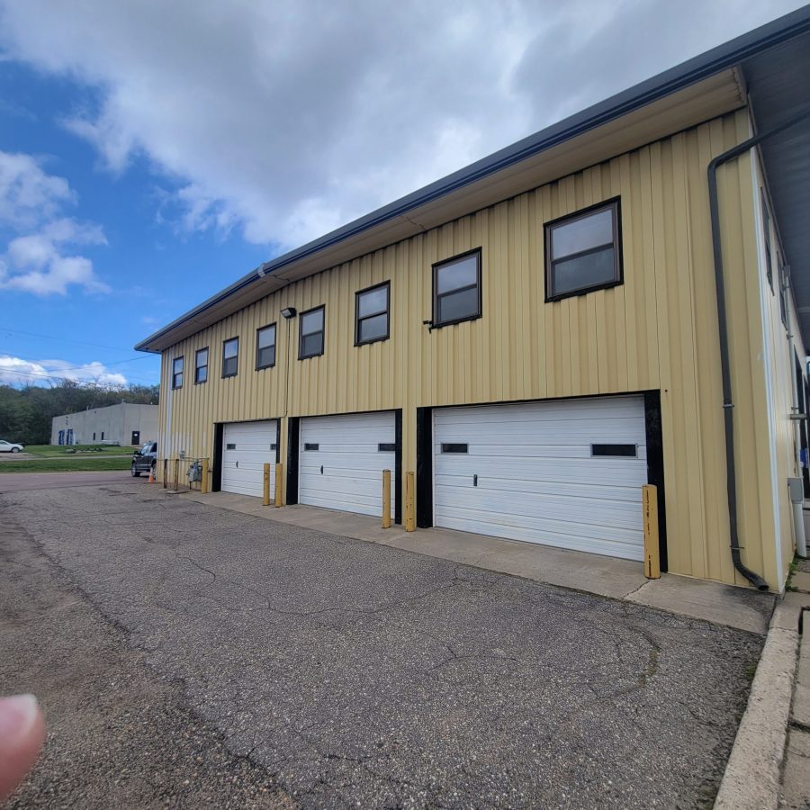 greyish yellow paint job done on commercial building with large white garage doors underneath gloomy weather in Le Center, Minnesota Preview Image 5