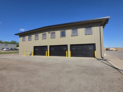 grey khaki commercial warehouse building with large black garage doors in Le Center, Minnesota.