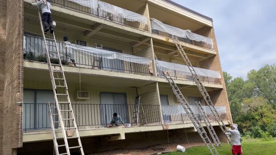 certapro painters using ladders to access balconies and paint patio walls at green circle drive condos during exterior painting