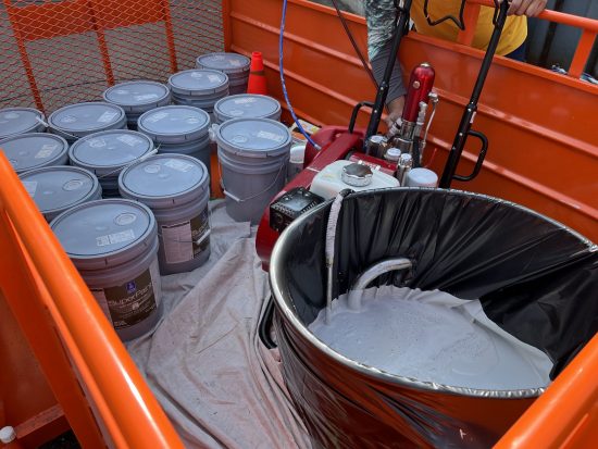 close up view of trailer set up containing gallons of paint and gas sprayer