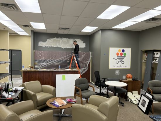 CertaPro Painter preparing wall for painting in The Food Group nonprofit offices in New Hope