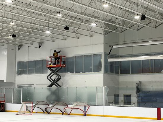 person on scissor lift painting wall