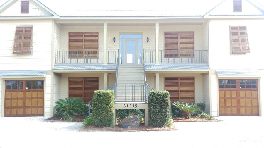 sidewalk view of residential building with stained wooden garage doors and window shutters Preview Image 4