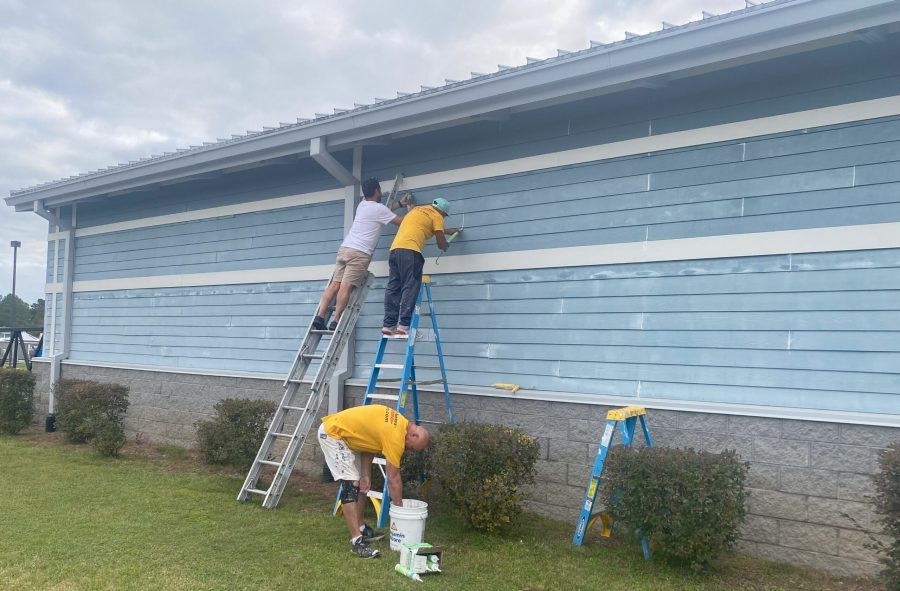 three painters on ladders working on side of commercial building Preview Image 9