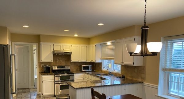 Newly painted tan kitchen with white cabinets