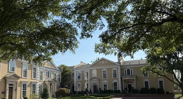 painters on ladders working on stucco exterior