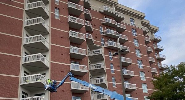 building with painters on boom lift