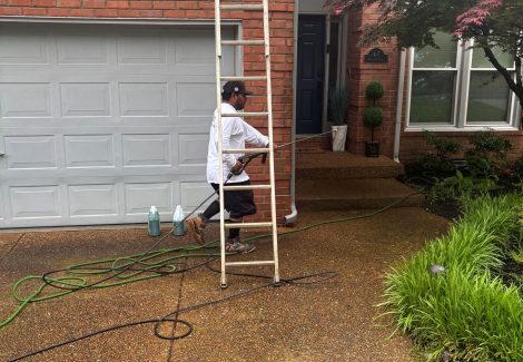 painters on ladders outside brick home