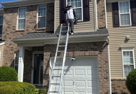 painter on ladder outside townhome