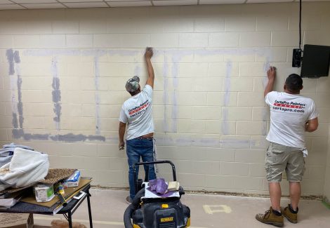 Painters at work painting interior wall
