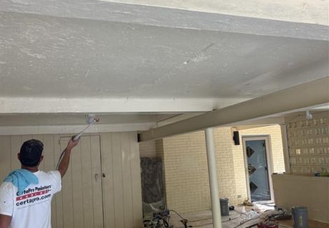 painter working on covered car park roof