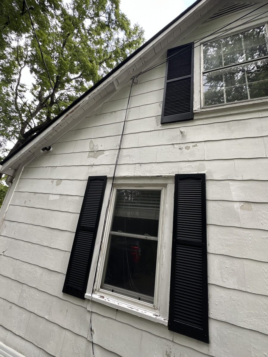 side of house with damaged white siding and black shutters Preview Image 12