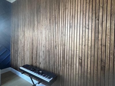 keyboard piano in front of wood accent wall