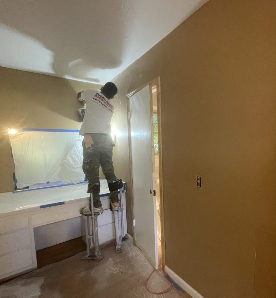 painter on stilts in home bathroom