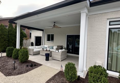 covered patio of white house with black painted trim