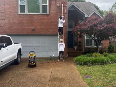 painters on ladder outside brick house