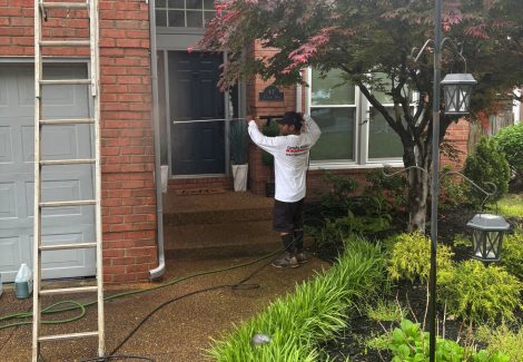 painters on ladders outside brick home