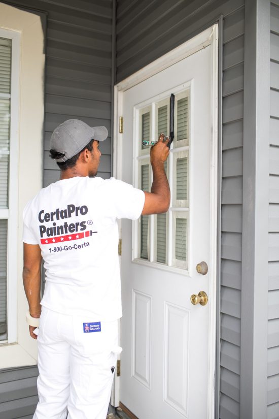 CertaPro Team Member painting front door of an HOA apartment