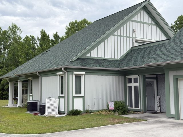 home exterior painted light sage green with darker green trim and accent areas