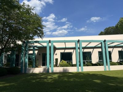 exterior of painted commercial building with teal green beams