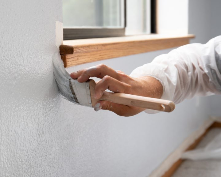 Man painting interior of home in gray paint