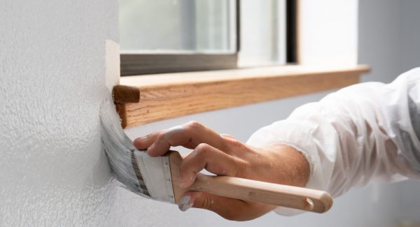 Man painting interior of home in gray paint