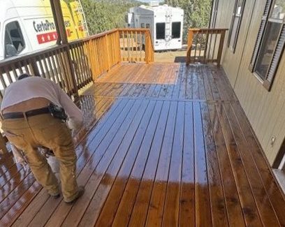 painter staining wooden deck