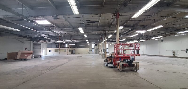 A scissor lift and painting supplies inside the tilt-up building. Preview Image 3