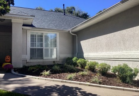 house exterior with faded stucco siding and damaged trim