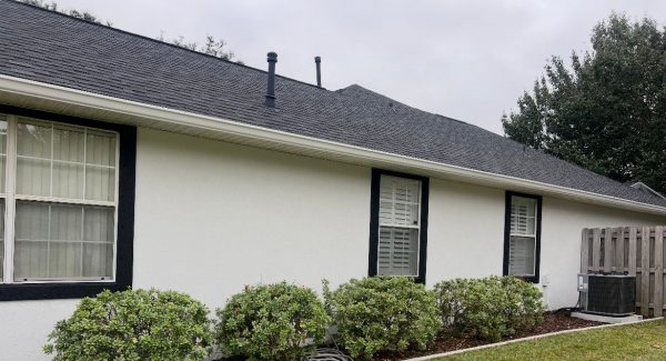 stucco house painted white with black trim and accents