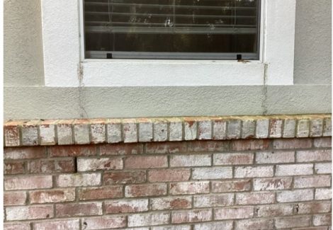 worn stucco and brick exterior