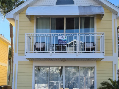 house with yellow painted siding and white balcony