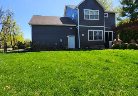 rear side grey painted two story house with yard
