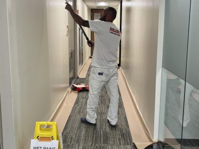 man painting commercial hallway walls