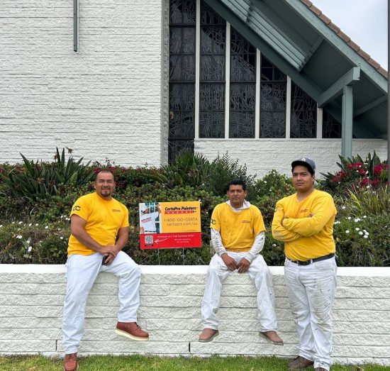 painting team sitting on church wall