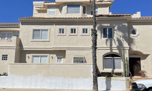 Stucco repair and repainting in progress.