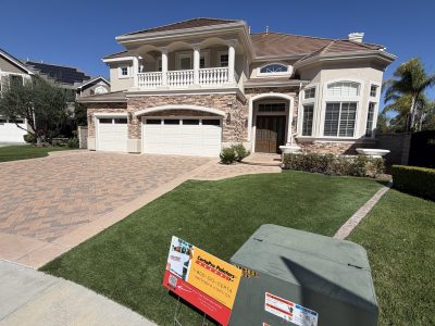 painted stucco and stone house exterior with upper balcony